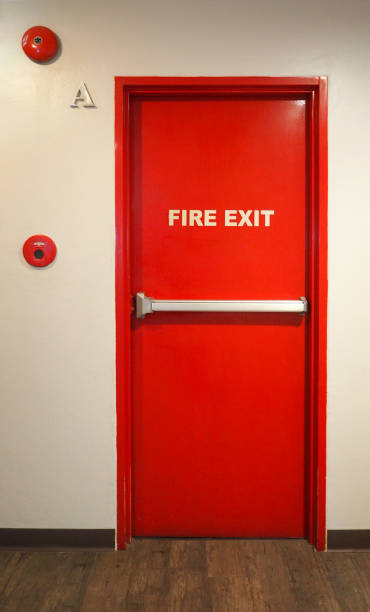 istock Emergency fire exit door and red color and white wall in building. 1319621782