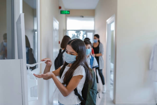 istock Little girl disinfecting hands while entering school. 1319622529