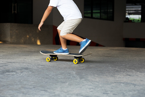 Little thai boy driving skateboard