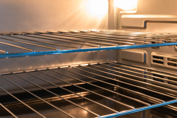 istock Empty open electric oven with a glowing element and metal rack 1319624136