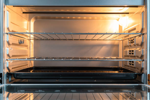 istock Empty open electric oven with a glowing element and metal rack 1319624286