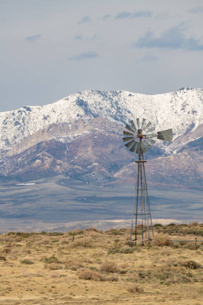 istock Western USA windmill with Mountain background 1319626898