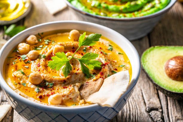 istock Chickpea hummus bowl closeup with pita flatbread dipping sticks on rustic wood 1319627416