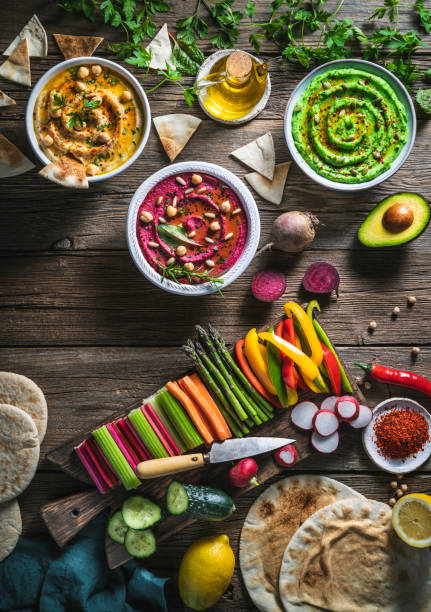 istock Hummus Three bowl of chickpeas, avocado and beetroot with cut vegetables for dip on rustic wood table 1319627550