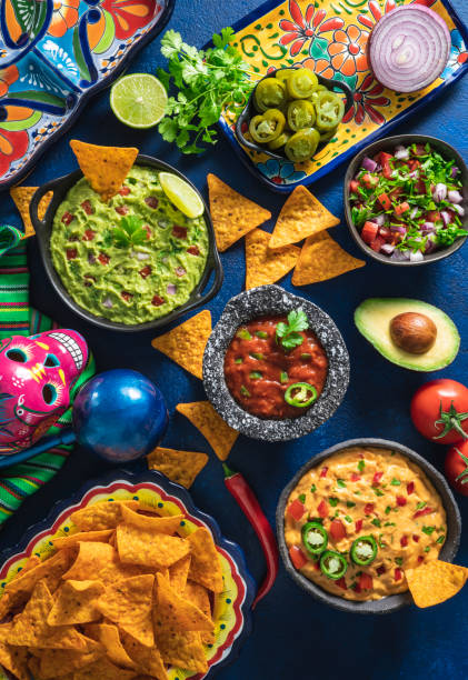 istock Mexican dip sauces guacamole, cheedar dip, tomato salsa and pico de gallo with Nacho chips 1319627670