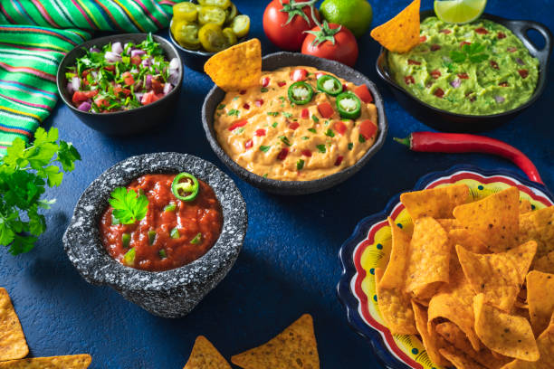 istock Mexican dip sauces guacamole, cheedar dip, tomato salsa and pico de gallo with Nacho chips 1319627761