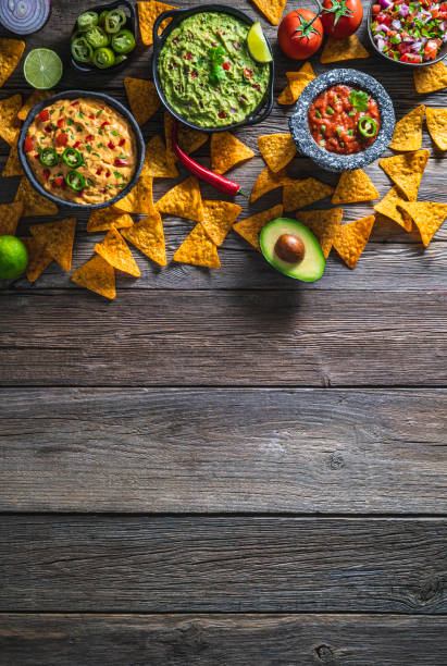 istock Mexican dip sauces guacamole, cheedar dip, tomato salsa and pico de gallo with Nacho chips 1319628320