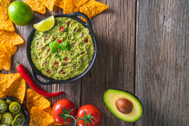 istock Guacamole dip sauce from avocado and Nacho chips with cilantro tomato and chili 1319628427