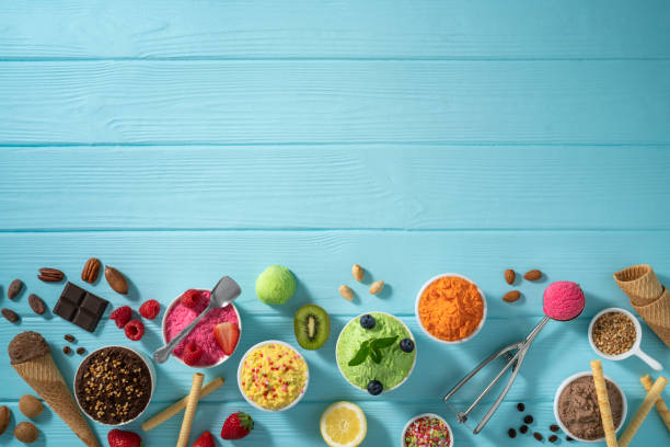 istock Assorted ice cream cups and waffle cones colorful different flavor on blue wood 1319628783