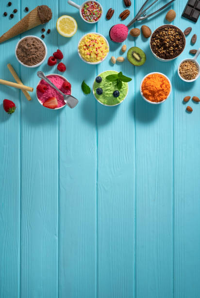 istock Assorted ice cream cups and waffle cones colorful different flavor on blue wood 1319628892