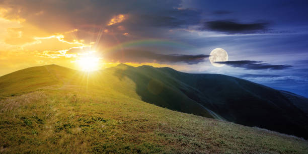 day and night time change above mountain landscape day and night time change concept above mountain landscape in summer. grassy meadows on the hills rolling in to the distant peak beneath sky with sun and moon day and night stock pictures, royalty-free photos & images