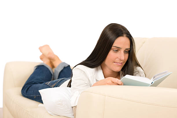 istock Attractive mid-aged woman read book on sofa 131963064