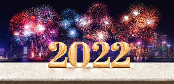 Happy new year 2022 (3d rendering) fireworks over cityscape at night with empty white marble table,Banner mock up template for display or montage of product for holiday promotion advertising.