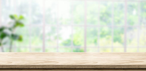 fondo de mesa de madera con ventana de desenfoque ver a través del jardín en casa. espacio de banner de maqueta para la exhibición de productos para publicidad en medios en línea - wood window fotografías e imágenes de stock