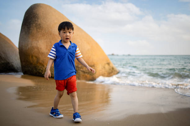 istock Asian  boy playing by the sea 1319631639
