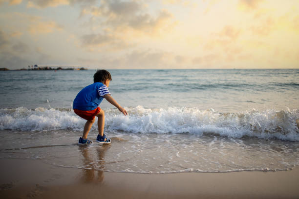 istock Asian  boy playing by the sea 1319631653