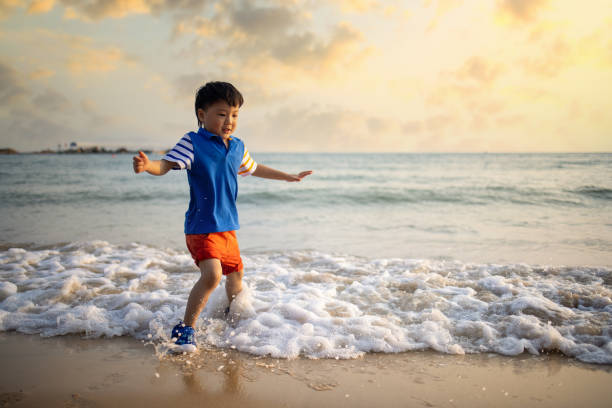 istock Asian  boy playing by the sea 1319631661