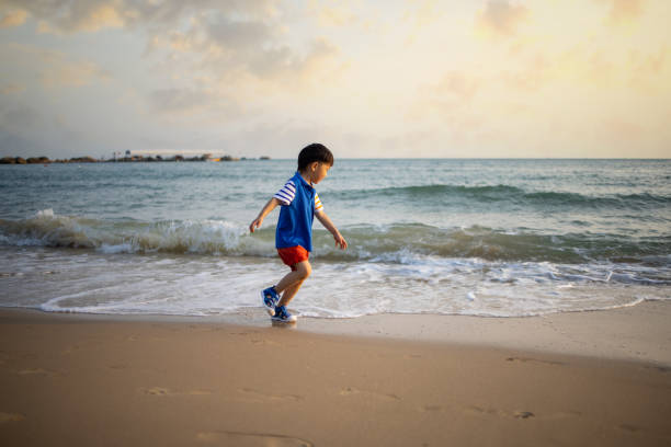 istock Asian  boy playing by the sea 1319631667