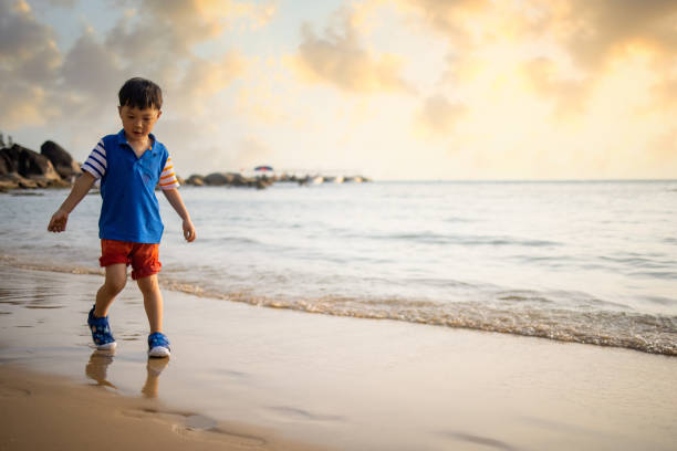 Asian  boy playing by the sea