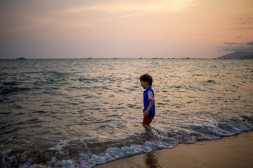 Asian boy playing by the sea