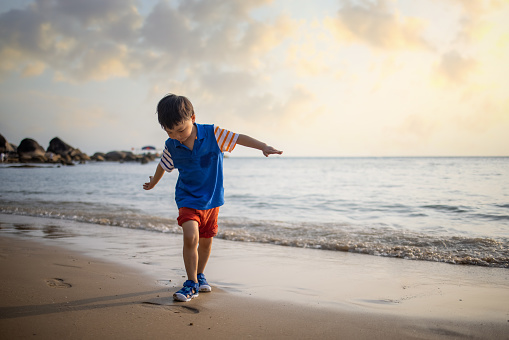 Asian boy playing by the sea