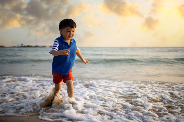 istock Asian  boy playing by the sea 1319631690