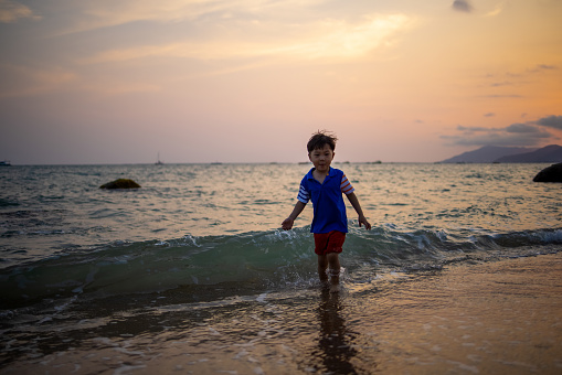 Asian boy playing by the sea