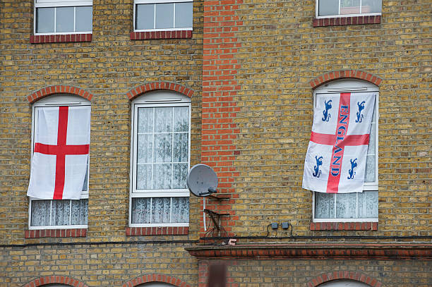 fenêtres avec deux drapeaux anglais cross - english flag st george flag flying photos et images de collection