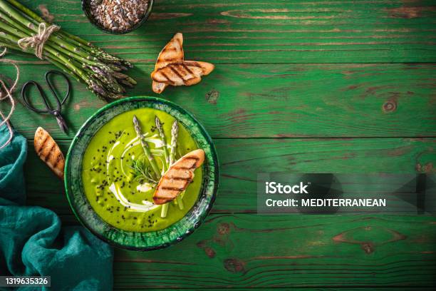 Asparagus Soup Plate With Ingredients And Bread Toasts On Green Wood Stock Photo - Download Image Now