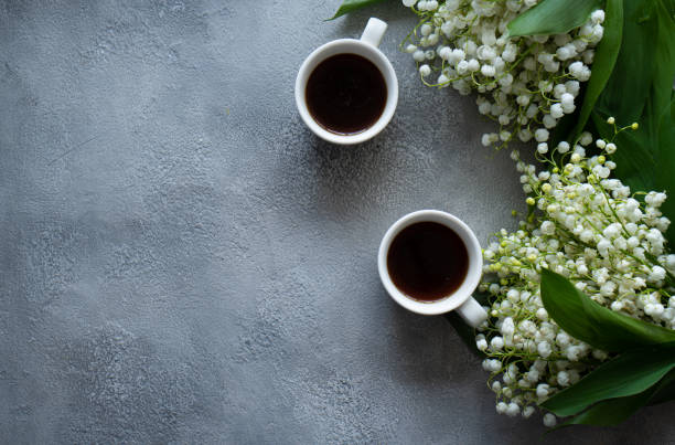 istock White cup with black coffee and flowers on a gray background. 1319636234