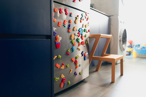 Colourfully decorated refrigerator with alphabet magnets of many colours