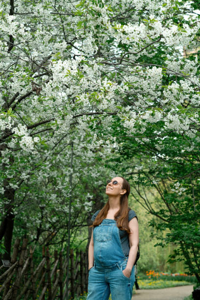 istock Pregnant woman in blooming park 1319637702