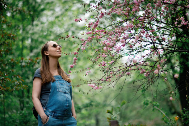 istock Pregnant woman in blooming park 1319638018