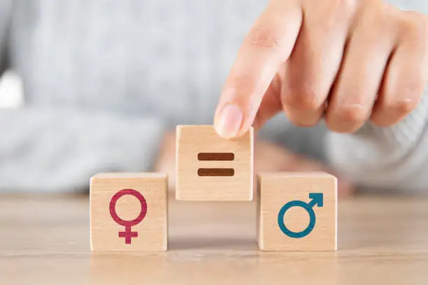 Female hand putting equal symbol between men and woman icons