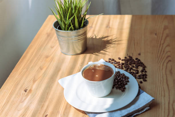 istock Morning coffe in white cup and roasted beans on a wooden table 1319639260