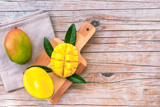 istock Mango on a cutting board on wooden backgrownd, top view, copy space 1319639269