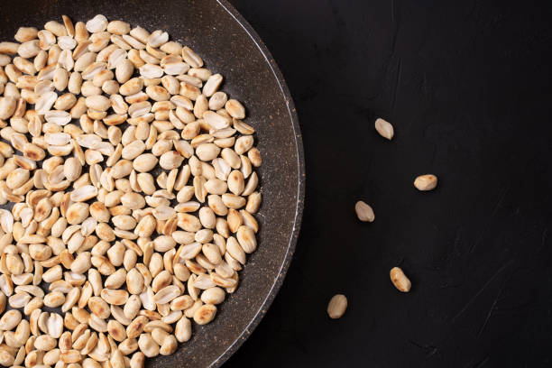 istock A large frying pan with roasted peanuts on a black background. 1319639677