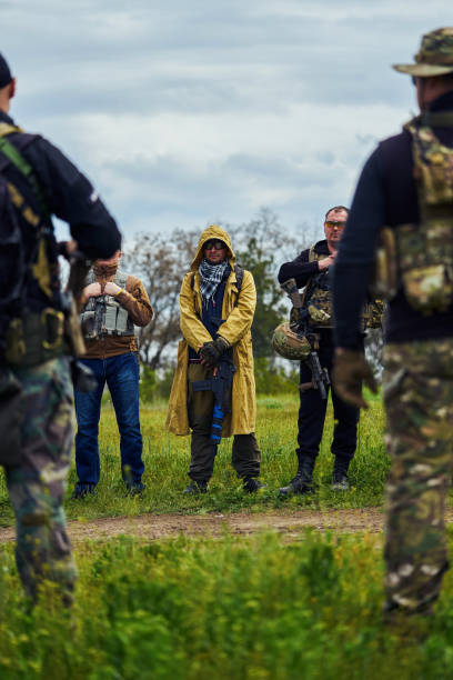 um grupo de jogadores de airsoft em uniforme com armas antes do início do jogo - conciliator - fotografias e filmes do acervo