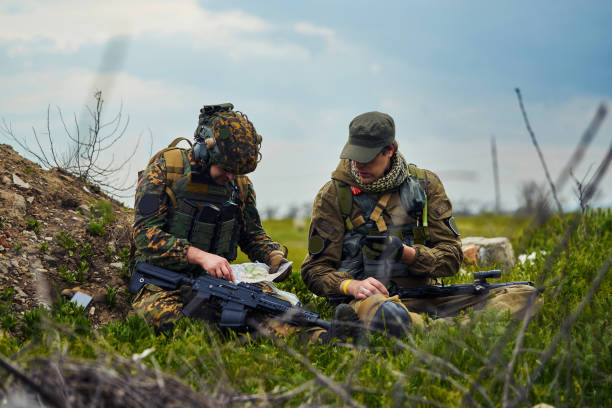 istock Airsoft players in military uniform watching a map 1319642228