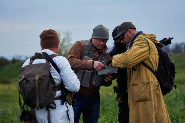 istock Airsoft players in military uniform watching a map 1319642263