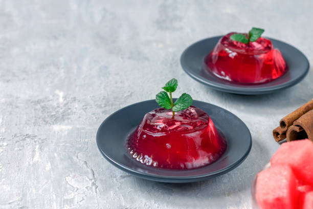 Pudding, jelly, Gelo di melone with mint and cinnamon on a dark plate on a light background. Homemade watermelon dessert. Copy space