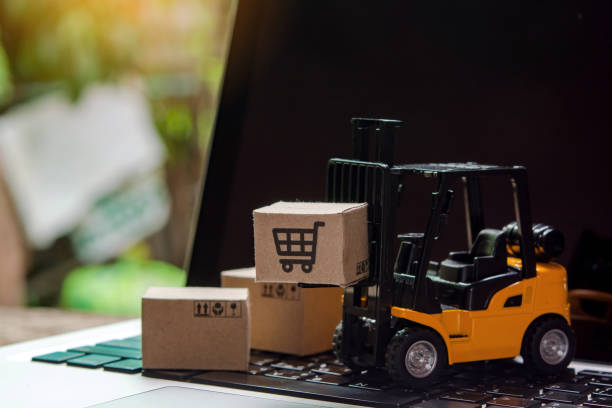 istock Forklift loader a pallet with Paper cartons or parcel on laptop 1319645574