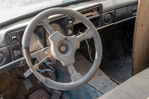 Ruined old car steering wheel closeup view