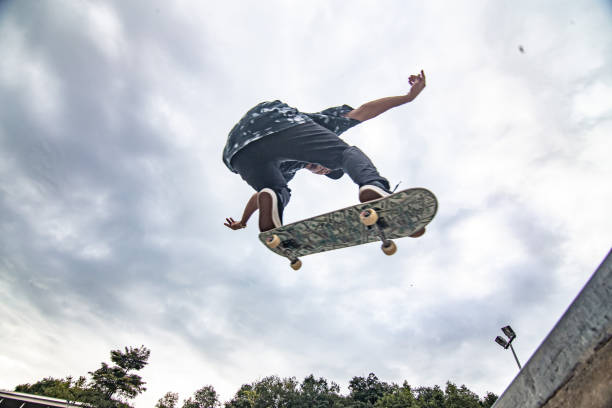 skater asiático en acción salta al aire - monopatín actividades recreativas fotografías e imágenes de stock