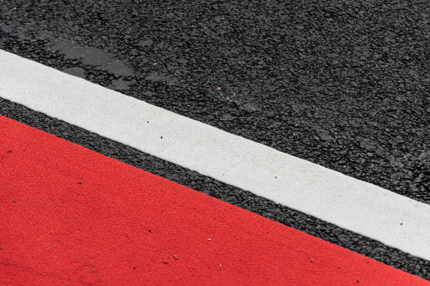 istock Asphalt decorated with a white line and a red field.. 1319648769