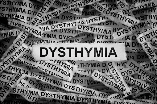 Dysthymia. Torn pieces of paper with the words Dysthymia. Black and white image. Closeup.