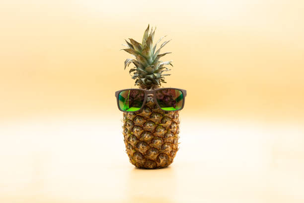 istock Funny pineapple with sunglasses over pastel yellow background 1319653672