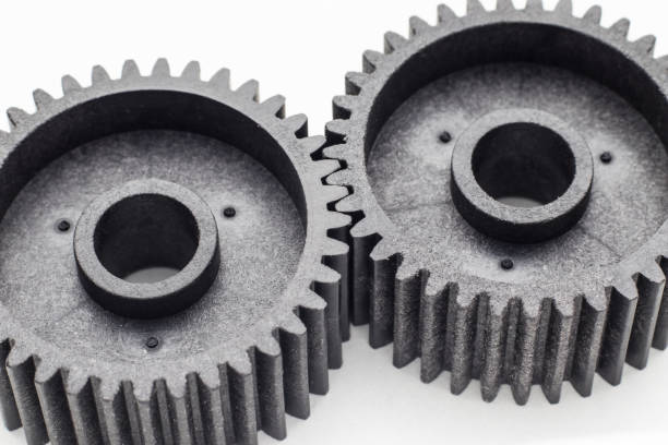 istock Two black plastic cog gears near 1319654498