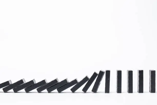 Falling black dominoes. Domino effect. Structural instability