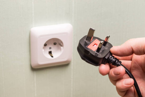 istock Different standards for electrical outlets. Unsuitable connector and plug in the hand of a person. Incompatibility, concept 1319654797